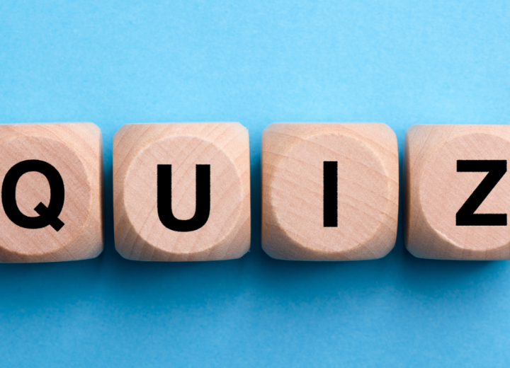 Wooden blocks with letters spelling out "Quiz". Blocks are on a blue backrgound.