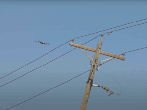Drone inspecting a power line pole.