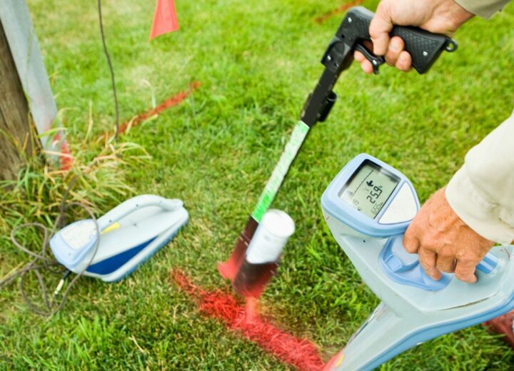 Photo of a worker marking utility lines with flags and spray paint.