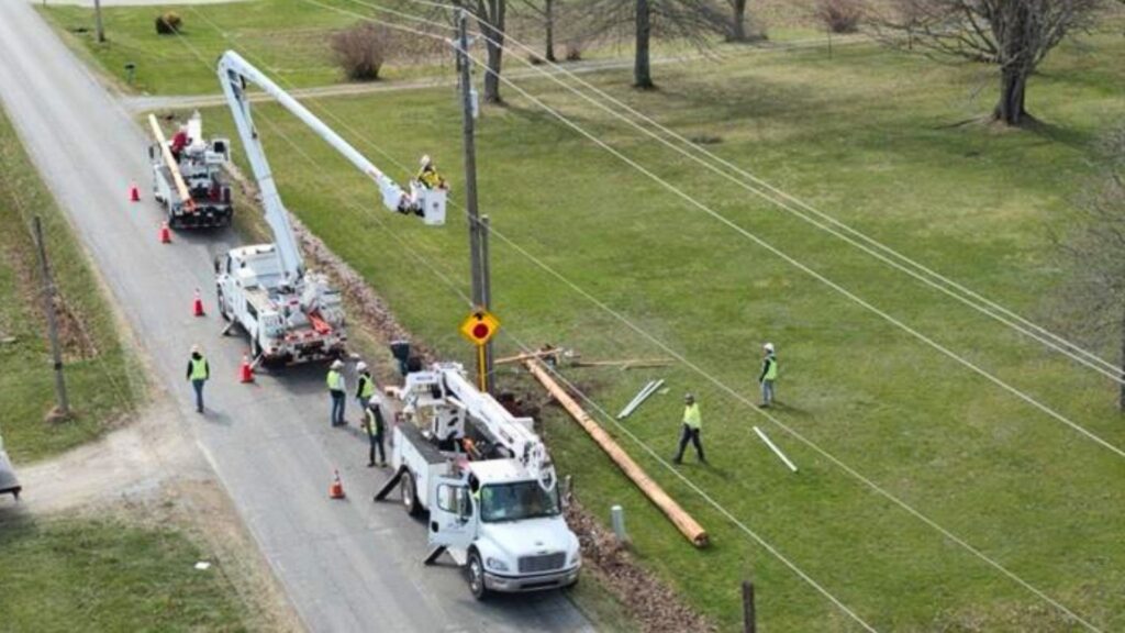 A photo of multiple crews setting a new power pole.
