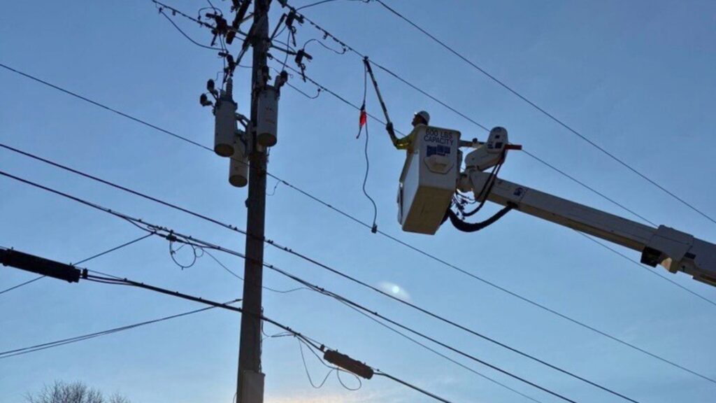 A photo of a lineworker closing a circuit.