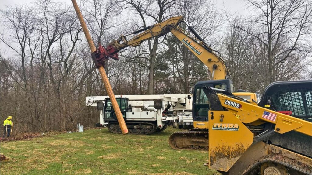 A photo of crews setting a new power pole.