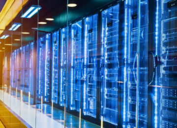 A photo inside a data center with servers and a warm light at the end of the hall